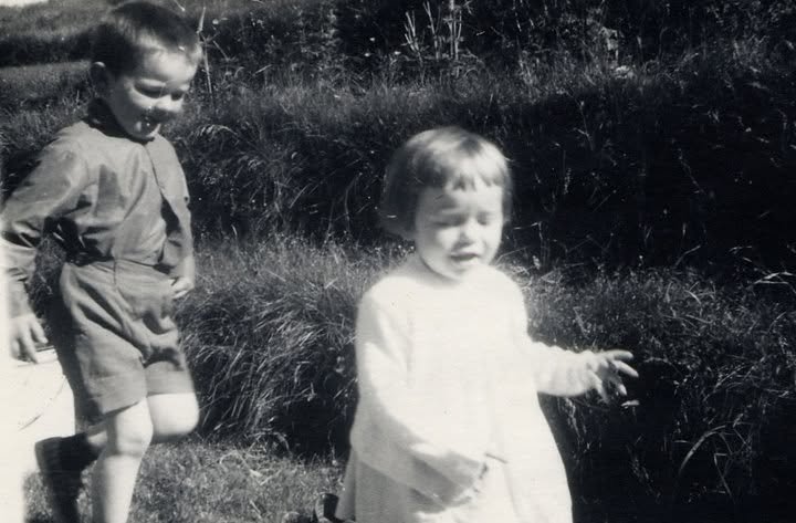María and a sibling as small children in long grass, Iceland, 1960s