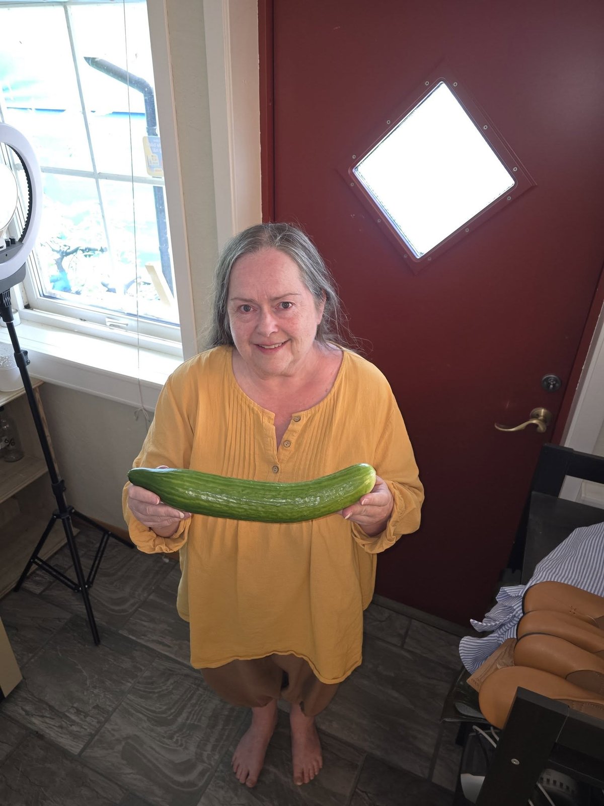 María holding a long cucumber from her own garden